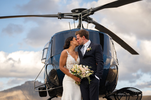 Couple kissing with bouquet and mountain views during Banff elopement