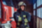 brave-fireman-wearing-protective-uniform-standing-fire-engine-garage-fire-department-cross