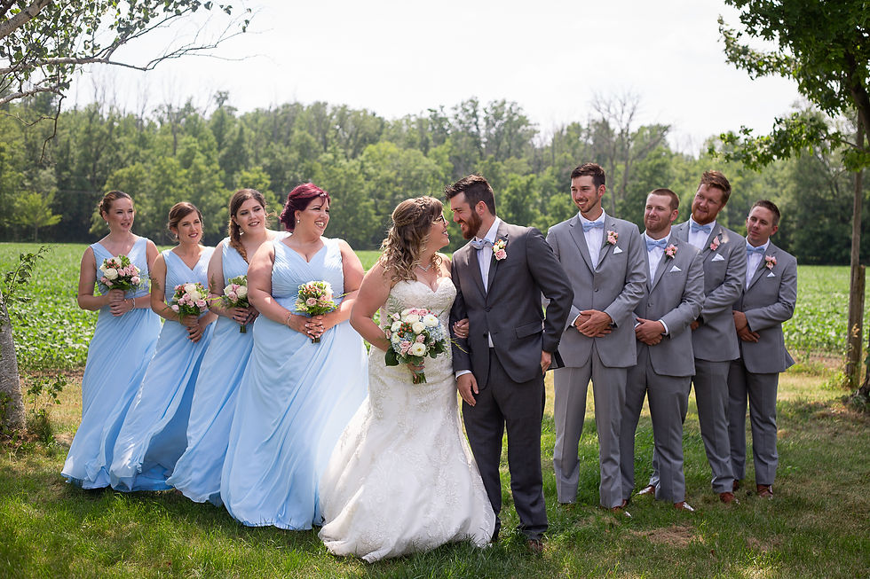 Wedding party outside in the country under trees. The men are in grey suits and the bridesmaids are in powder blue floor length dresses. London Ontario Wedding Photography Lori Beneteau Photography