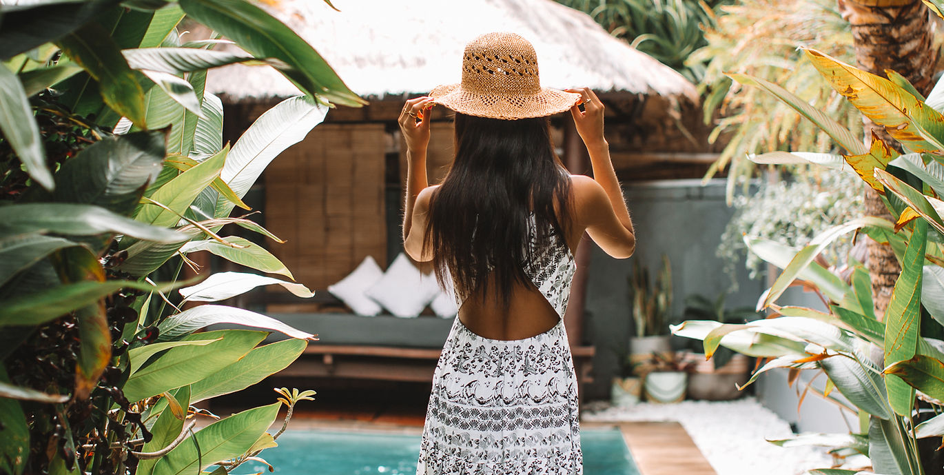 Girl in hat entering villa