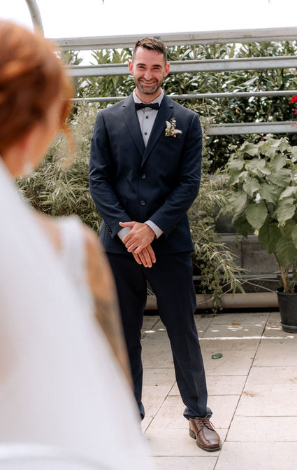 DIY Hochzeit, Freie Trauung Fürstenfeldbruck, der Brutigam steht der Braut gegenüber und lacht sie glücklich an 