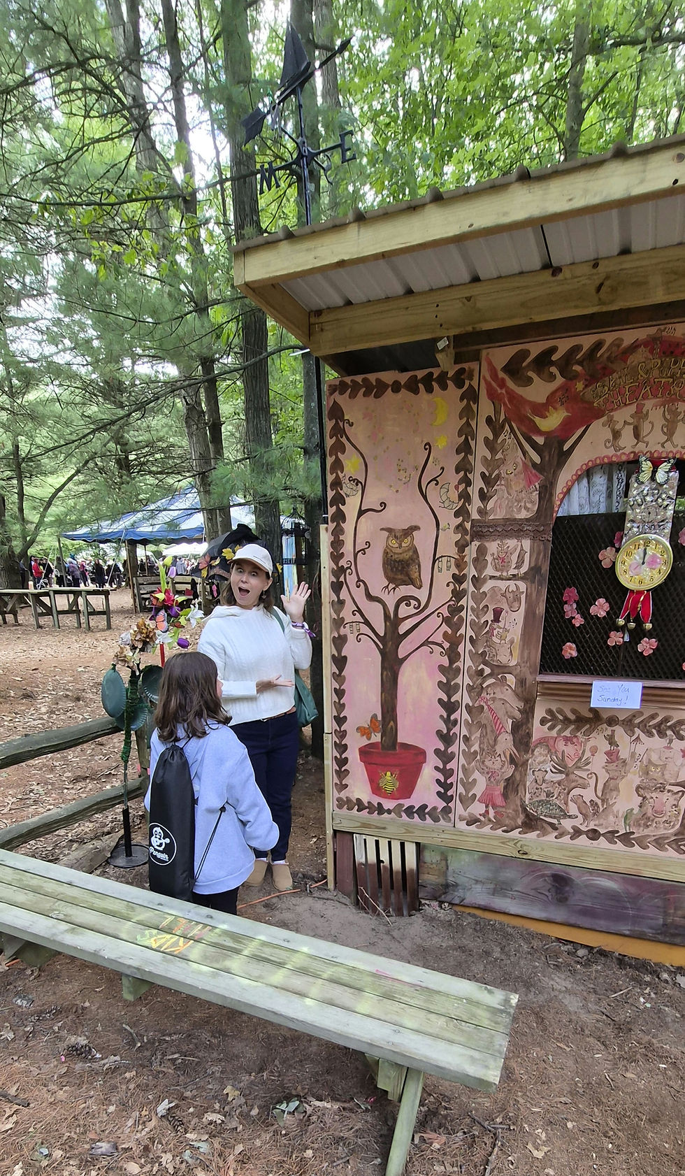 Those readers who know me well can probably imagine exactly what my expression is saying in this photo: "Look, Cordelia, we stumbled upon the perfect theater for the Kirkos Caravan!" The owl, the bee, the butterfly, the tree, the clock face, the boat topped weather vane, the folk art... these are all themes, motifs, and designs that make up the Kirkos Caravan, my partly fictional traveling family performance troupe. Cordelia, with her new ukulele on her back, may be my last hope for getting one of my family members to join my (now) one woman show. This puppet theater appeared in the woods on the grounds of the Wheatland Music Organization since last year's festival, and I eagerly anticipate seeing a show there tomorrow. Today I spent 8 hours at the Elephant Ear wagon selling the sugary treats to festival go-ers, while Tony flipped burgers at the Knights of Columbus wagon. I've been attending this festival since I was 12 years old, so it's undoubtedly played a role in my artistic ambitions. Over the years, the festival has become a tradition for my kids as well, and if Cordelia's decision to take up the ukulele today is any indication, it has worked its inspirational magic upon her as well.