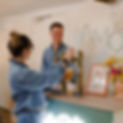 Couple souriant servant une boisson pression au bar.