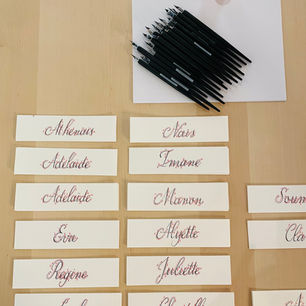 Marque-pages préparés avec prénoms des participants pour un atelier de team building d'initiation à la calligraphie moderne à la plume