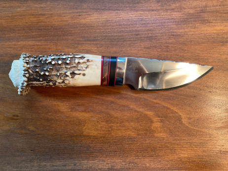 #274 Large Hunting Knife with Deer Antler handle and gem composite, steel bolster. Price is $250.