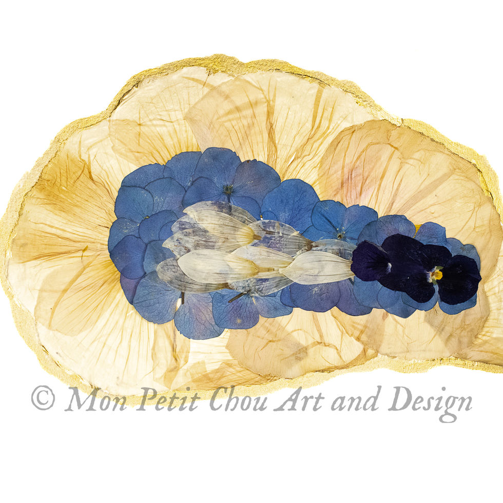 Pressed flower oyster art titled Harvested by Moonlight, featuring real blue and gold pressed petals in an oyster silhouette.