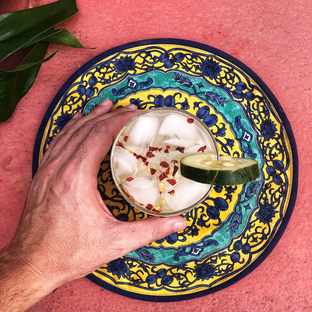 hand holding a cocktail on colourful plate
