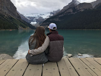 Couple sitting down looking out onto Lake louise.