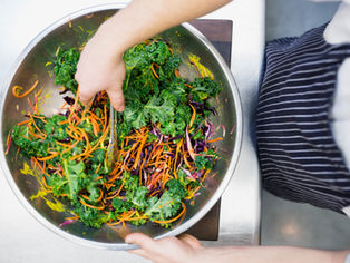 tossing a kale salad