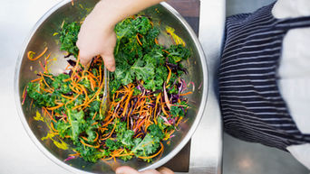 tossing a kale salad