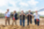 Group o people with shovels at a retail store's ground breaking
