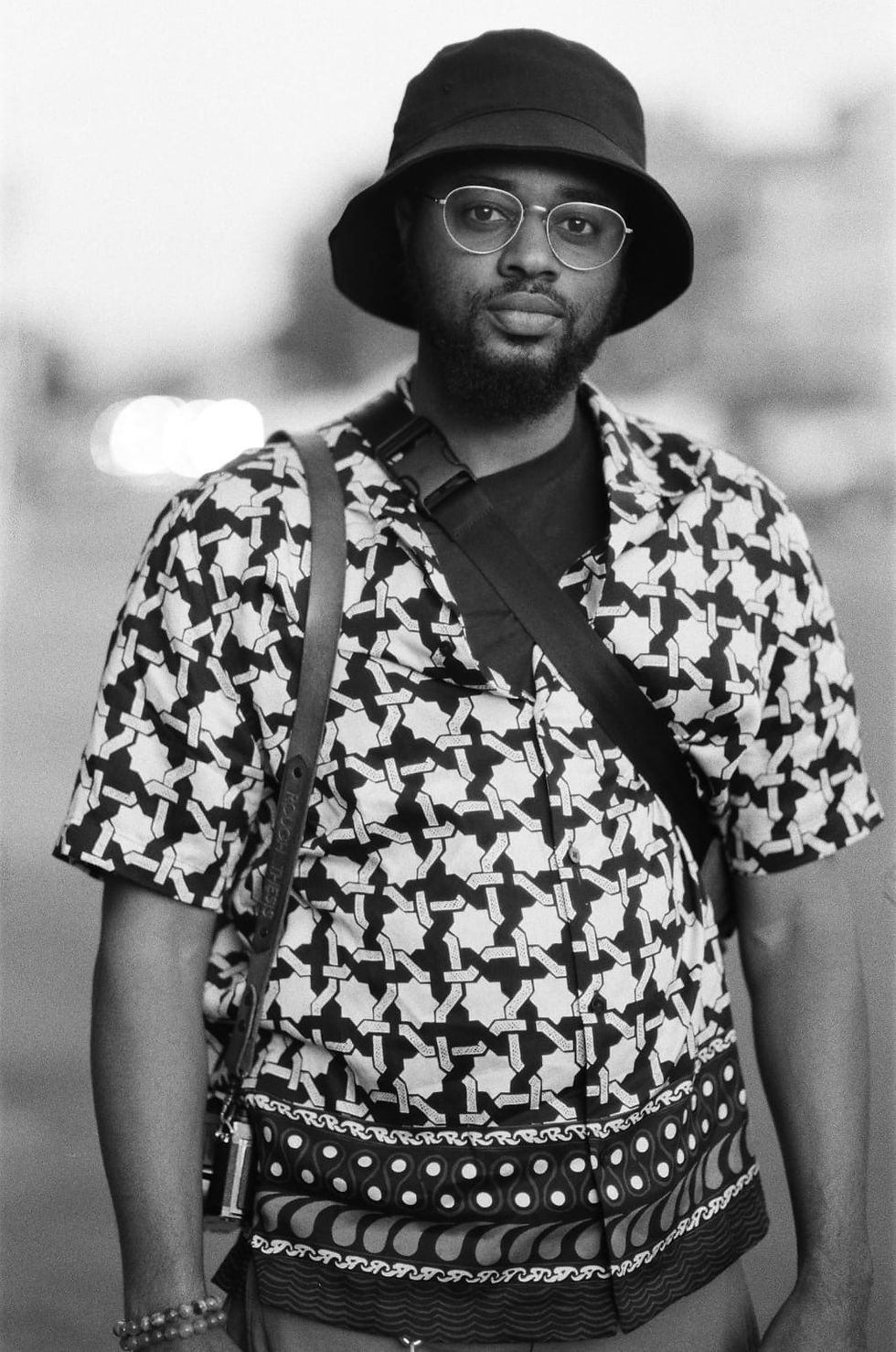 Black gentleman with graying hair standing outside on a sunny day
