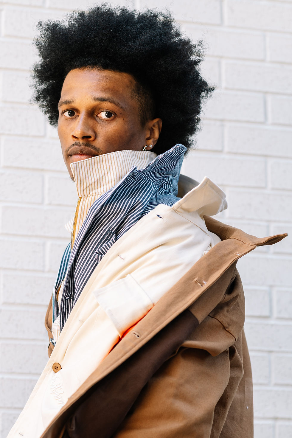 Black man with afro modeling fall fashion workwear by brand Mannish