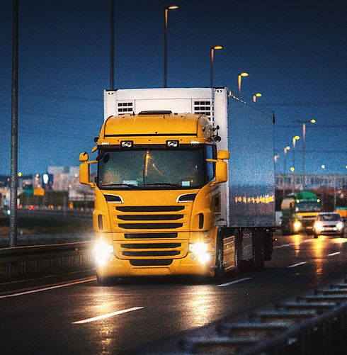 yellow lorry driving on the motorway at night