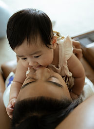 a tween son kisses his baby sister on the cheek