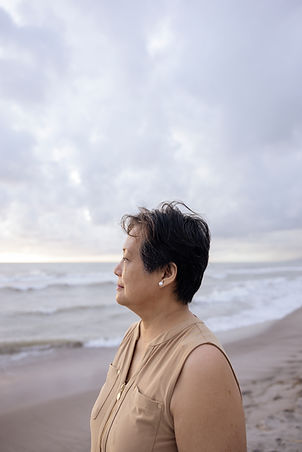 woman on a beach looking at the view of the water