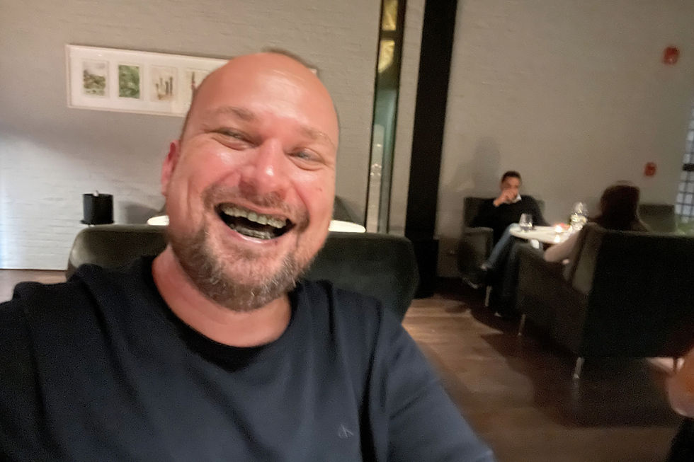 Traveler laughing after a playful dessert at Leo in Bogotá - a memorable foodie moment during gay Colombia travel.
