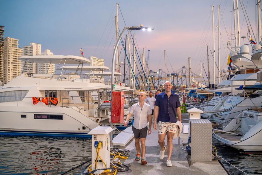 Gay travelers boarding a private catamaran in Cartagena for a luxury LGBTQ+ party hosted by OUT in Colombia