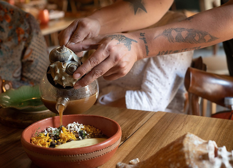 Chef pouring a Caribbean-inspired sauce into a dish at Celele restaurant in Cartagena — a highlight of Colombia foodie experiences and gay Cartagena travel.
