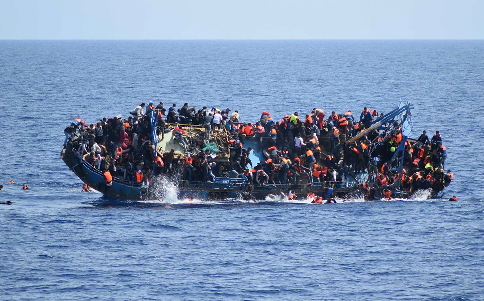 Overcrowded boat packed with people in orange life vests on open sea, with some falling into the water.