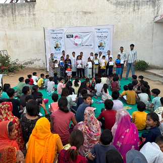 A view from the back of the group of gathered girls & women. Outdorr setting.