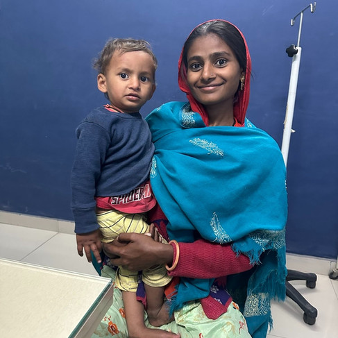 A mom and her child sitting by the exam table in the clinic.
