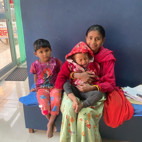 A mom and her child sitting by the exam table in the clinic.
