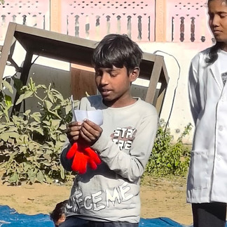 A boy reads his message. Behind him is a broken table and a SKT staff member. 