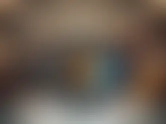 Masquerade ball scene with attendees in ornate masks and gowns under chandeliers. A computer on a table displays a feathered mask image.