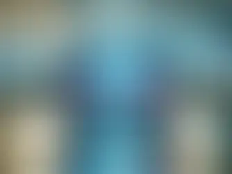 Laptop with colorful data graphs on screen in a futuristic computer lab. Blue neon lights illuminate multiple workstations in the background.