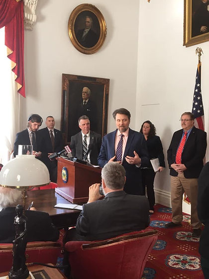Chris speaking in front of the Governor and staff