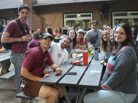 group of young adults sitting at picnic table
