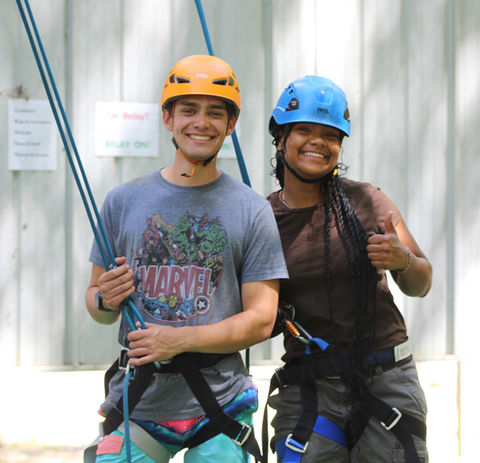 male and female counselors in zipline gear