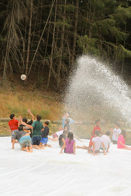 kids playing ball on slip and slide