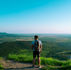 Person standing on a mountain or horizon at sunrise looking forward