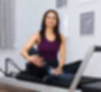 Reformer Pilates Instructor Sitting On A Reformer.jpg