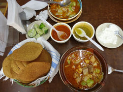 Pozole, tostadas, crema, chiles y limn