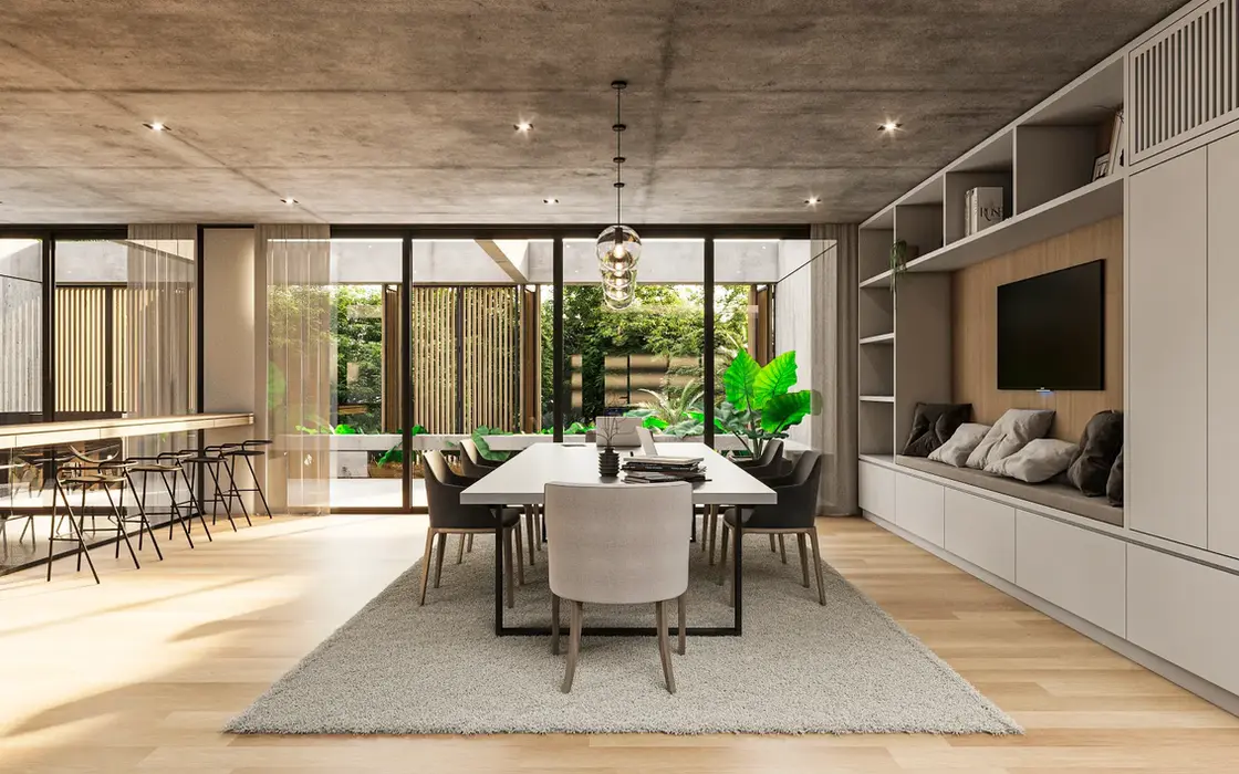 Playrrom con piso de marmol y losa de hormigon visto. hay un ordenador empotrado con un mueble para tv. Una mesa de estudio con sillas y alfombra.