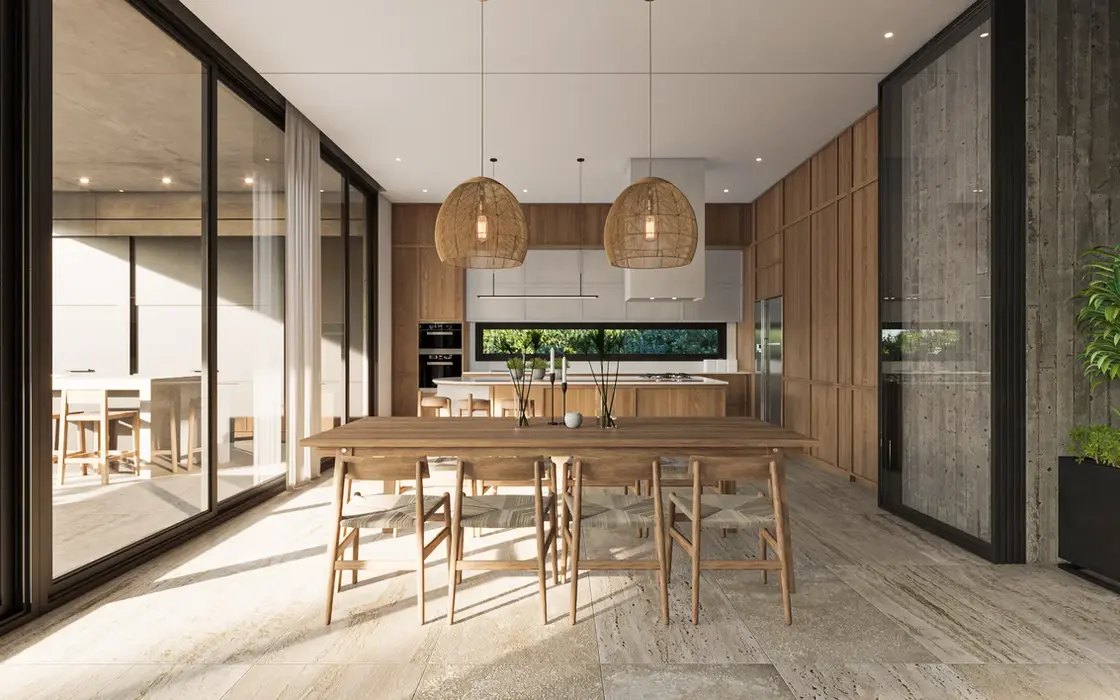 Cocina con muebles en madera y laca blanca. se ve el comedor con lamparas colgantes sobre la mesa.