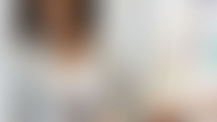 Woman presenting during a startup workshop, gesturing toward a whiteboard with notes and photos.