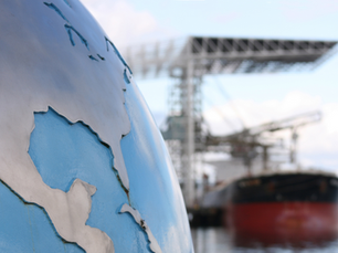 Globe in front and cargo ship in the back