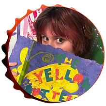 Mia is a young white woman. She has short, auburn hair. She is playfully hidden behind a hand-made book, peering over the top in a coy way.