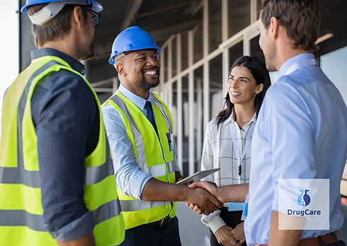 Professional wearing a hardhat and Vest is smiling as he shakes hands with Employees 
