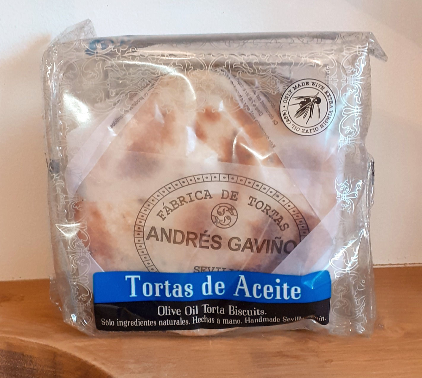 traditional spanish torta olive oil biscuits in a plastic pack on a wooden shelf