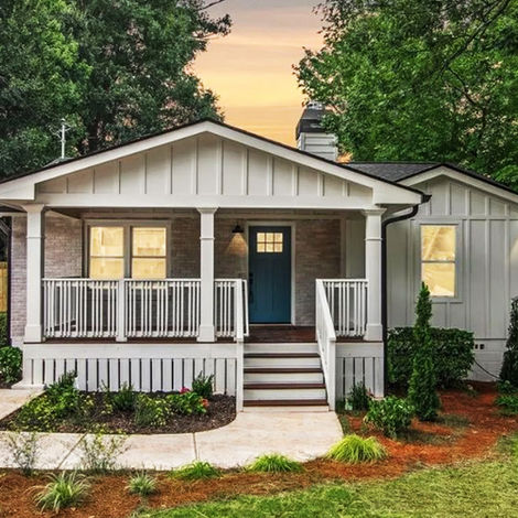 Renovated bungalow-style home in Smyrna, Georgia featuring a covered front porch, board-and-batten siding, landscaped yard, and modern exterior finishes.