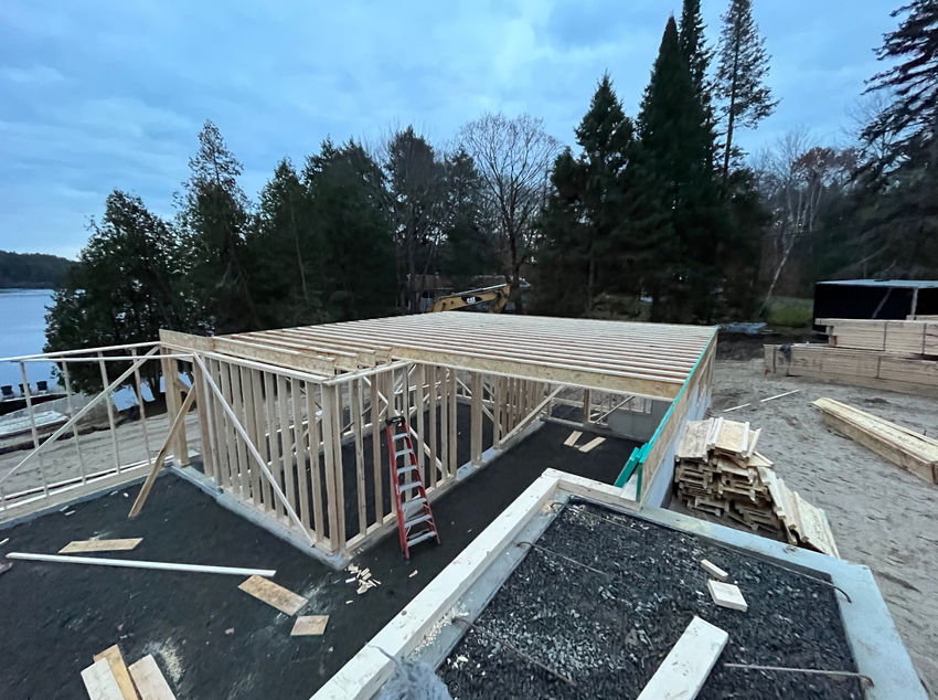 Construction site of a house showing just the wooden frame of the main floor's walls and ceiling.