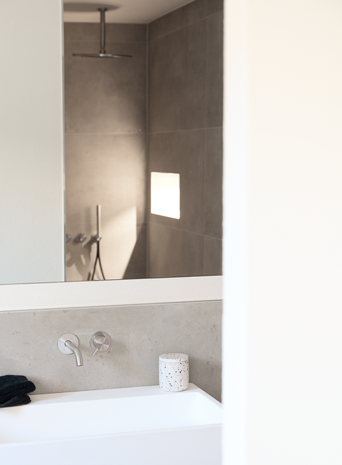 Modernes Bad mit Waschbecken und Spiegelreflexion der Dusche