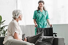 senior-woman-looking-smiling-female-nurse-with-wheelchair.jpg