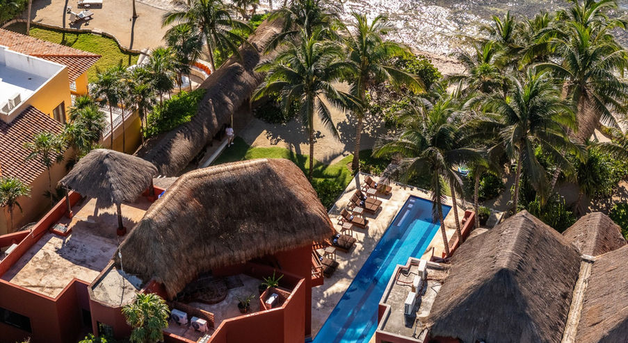 Aerial view of Jade Bay beachfront villa in Akumal with pool, palm trees, and Caribbean Sea views