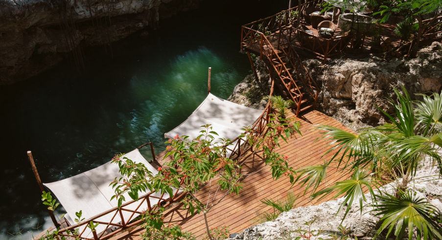Cenote jungle retreat for sale in Akumal with wooden deck and natural swimming area